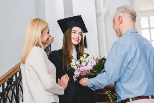 How to Graduate a Homescooler - parents presenting graduate with flowers