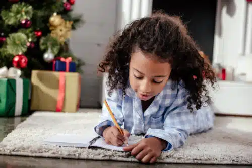 Girl writing in notebook - holiday learning