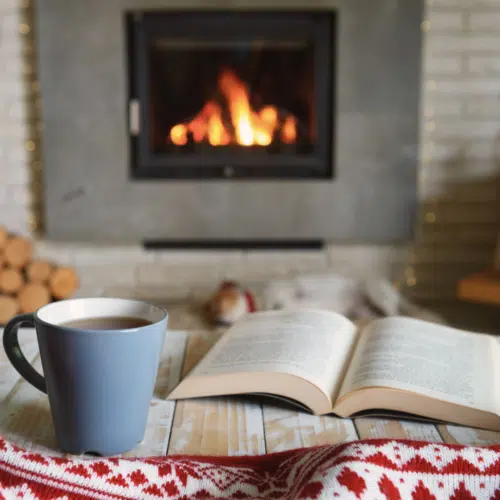 50+ Super-Cool Winter Study Ideas - warm drink and book beside fireplace