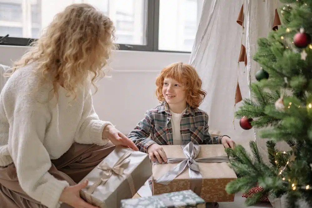 gift ideas for moms - mother and son with gifts by Christmas tree