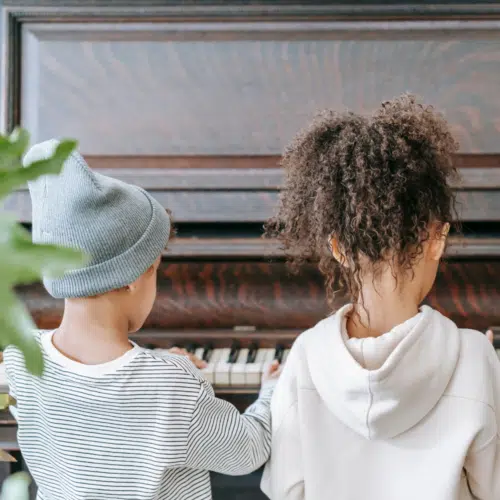 two children playing piano